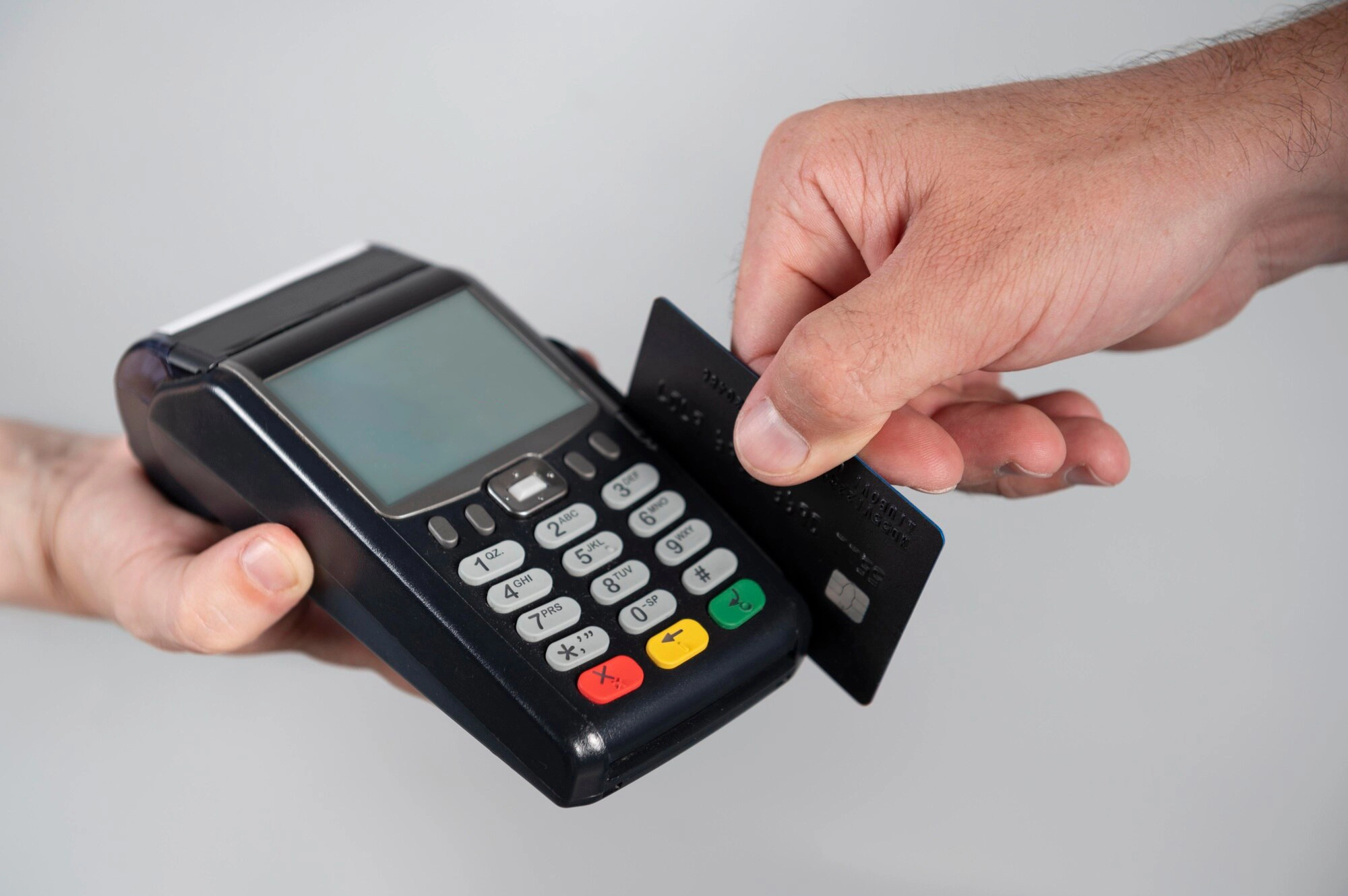 Pessoa pagando com cartão de crédito na maquininha (Imagem: Freepik)